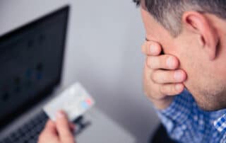 Man holding a credit card being Sued by a Debt Collector in California.