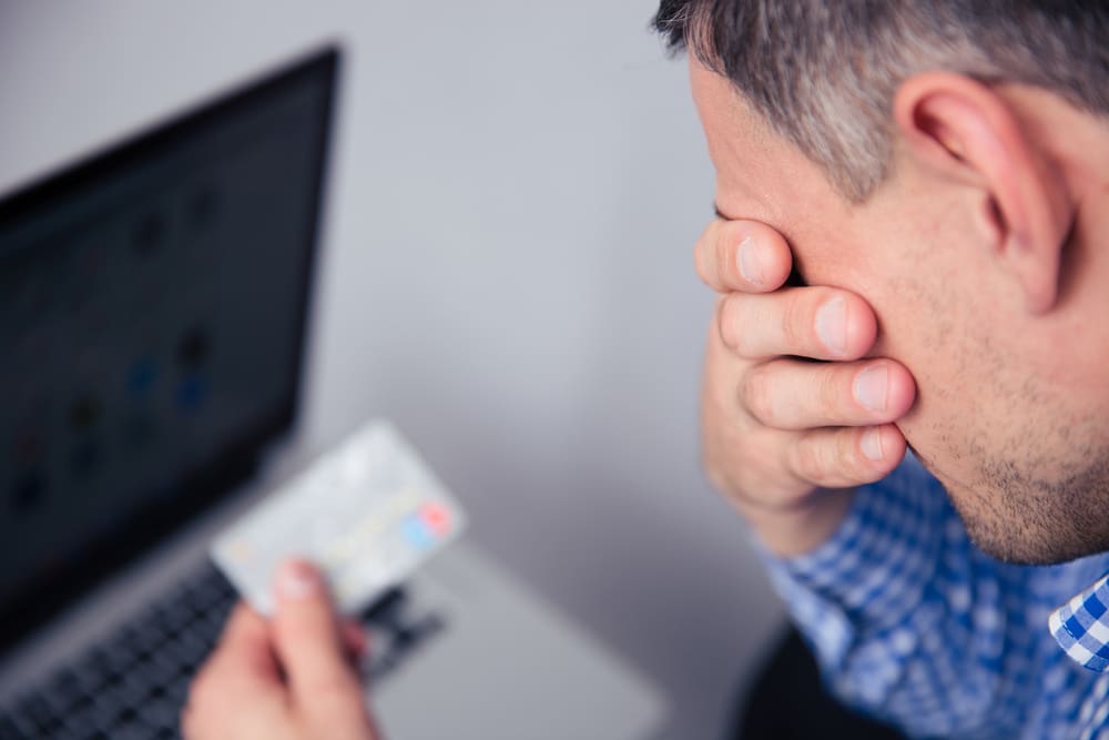 Man holding a credit card being Sued by a Debt Collector in California.