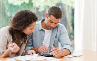 Couple looking at bills - types of debt repayment in Los Angeles California Serving San Bernardino, Riverside County, & Los Angeles County