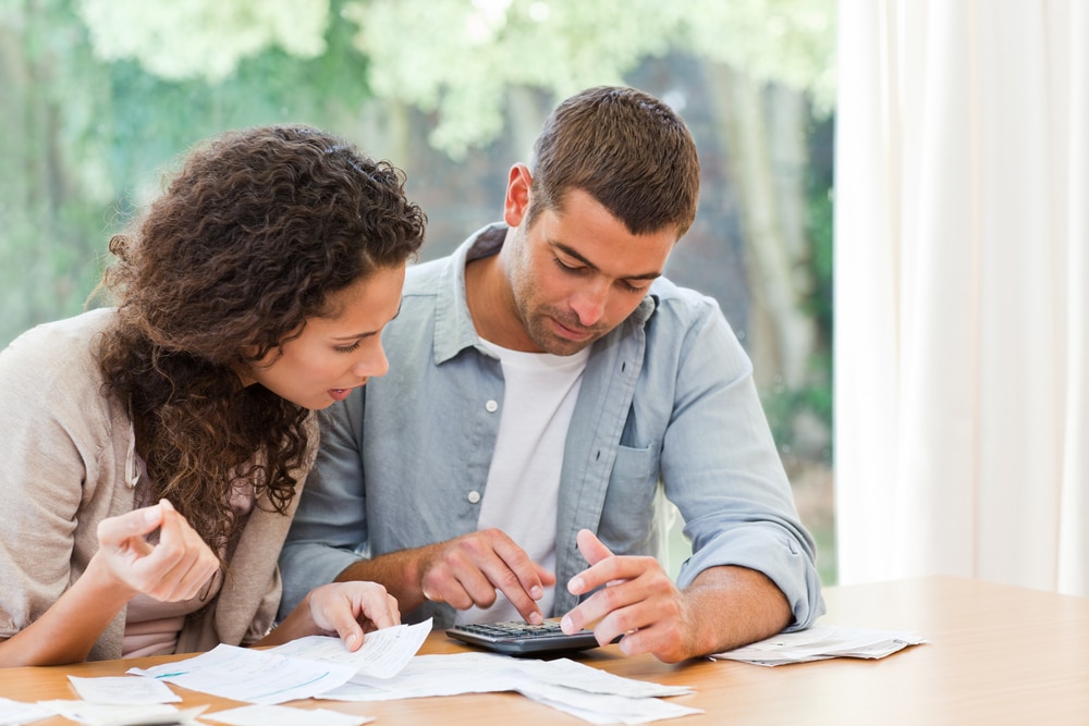 Couple looking at bills - types of debt repayment in Los Angeles California Serving San Bernardino, Riverside County, & Los Angeles County